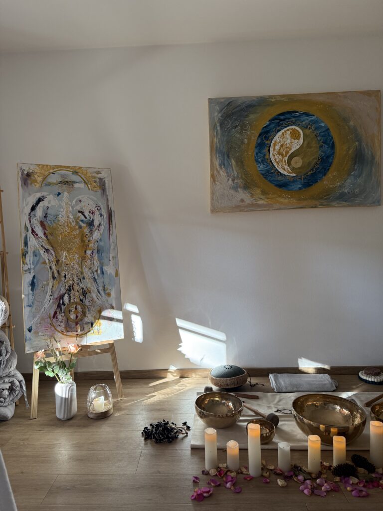 Kunstwerke hinter Klangschalen und Kerzen