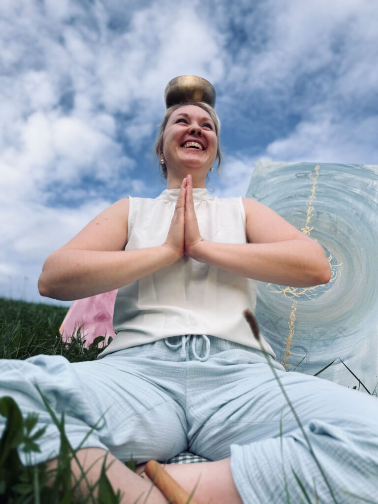 Frau sitzt in der Wiese